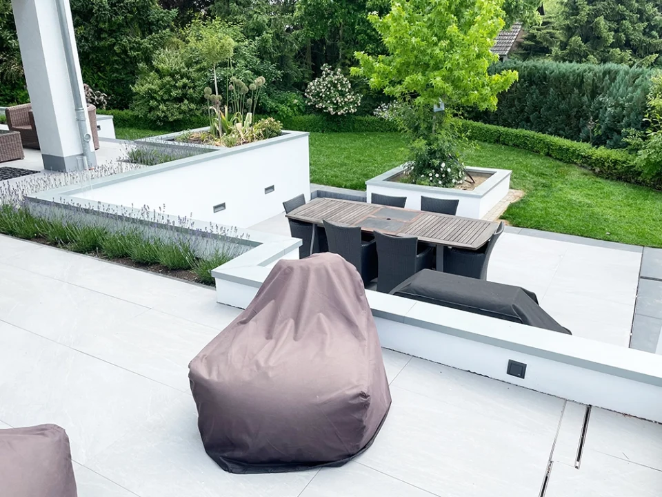 Moderne Terrasse auf zwei Ebenen mit geschmackvollen Fliesen und Grünflächen